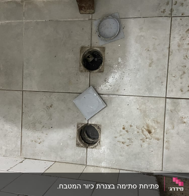 פתחי ניקוז פתוחים ברצפה עם מכסים מונחים בצד